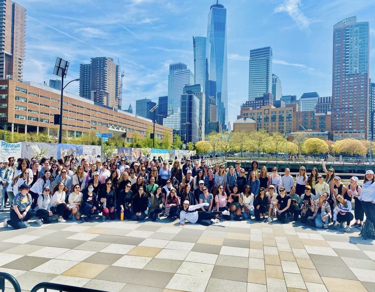 A large group photo of women in a New York City park